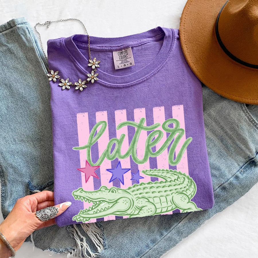 May include a Later Alligator Comfort Colors Tee featuring a playful alligator-inspired statement design on a casual short-sleeve shirt.