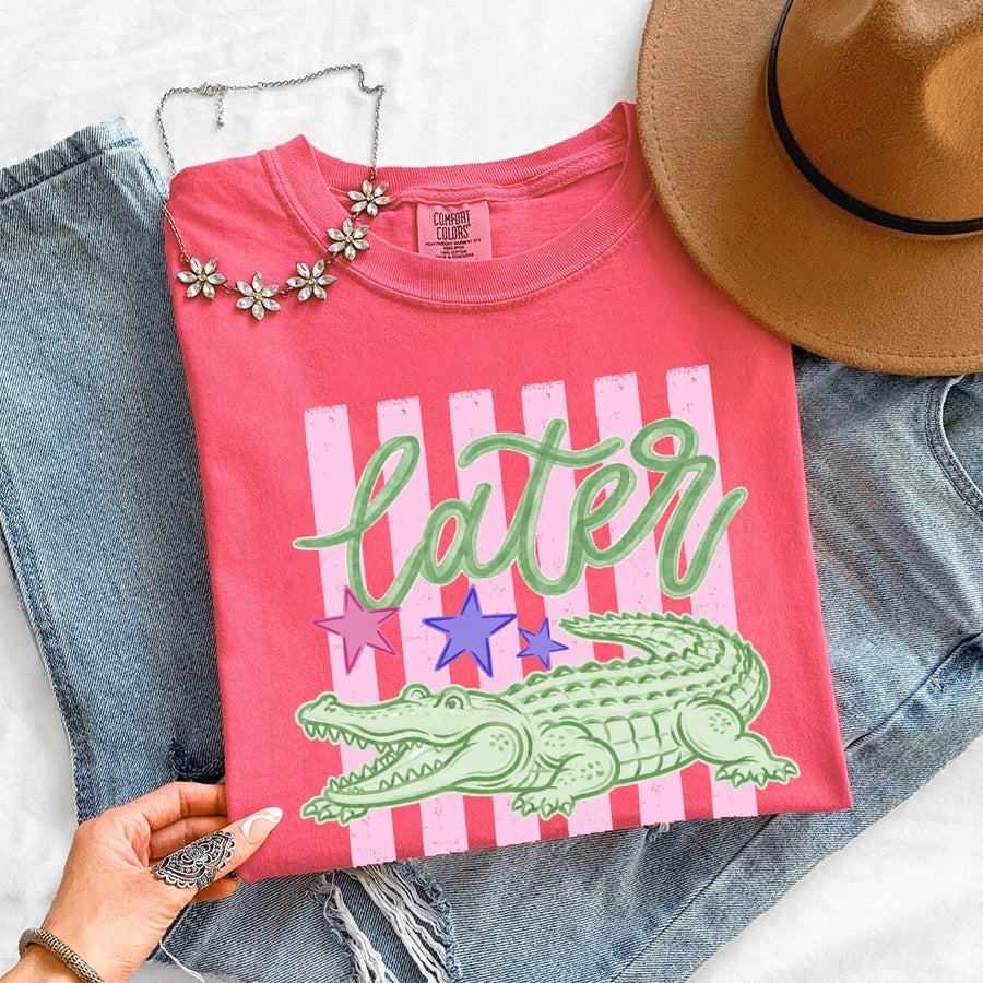 May include a Later Alligator Comfort Colors Tee featuring a playful alligator-inspired statement design on a casual short-sleeve shirt.