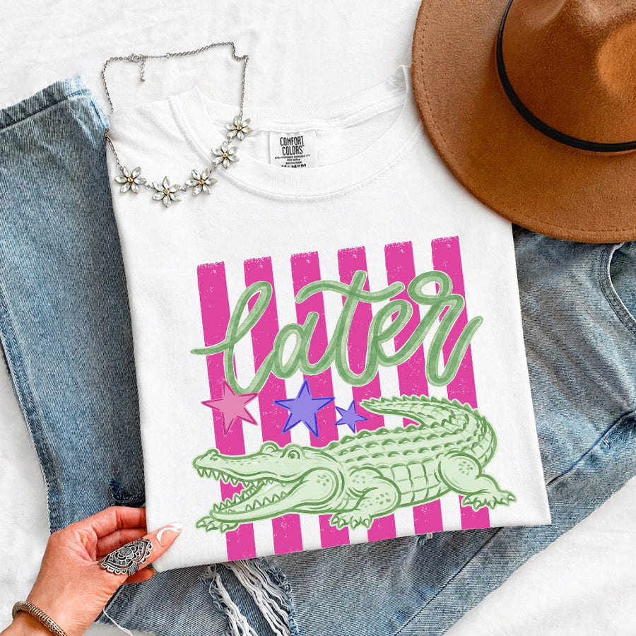 May include a Later Alligator Comfort Colors Tee featuring a playful alligator-inspired statement design on a casual short-sleeve shirt.