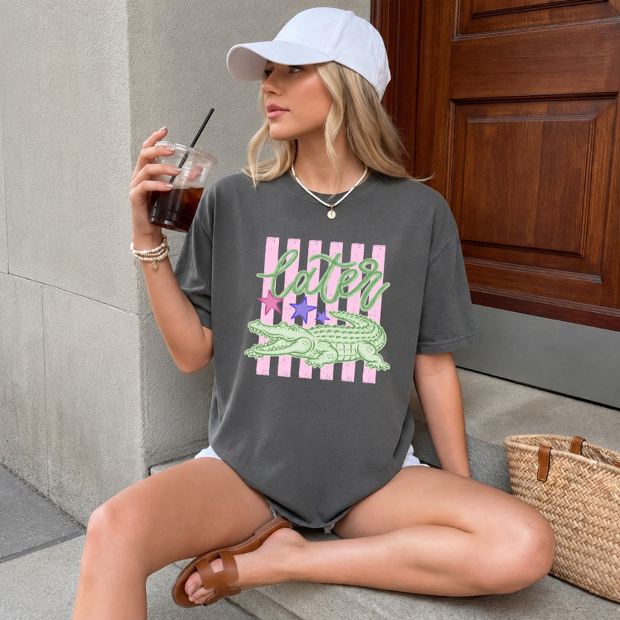 May include a Later Alligator Comfort Colors Tee featuring a playful alligator-inspired statement design on a casual short-sleeve shirt.