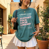 May include a Support Your Local Library Comfort Colors T-Shirt featuring a classic library-inspired statement design.