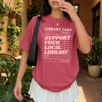 May include a Support Your Local Library Comfort Colors T-Shirt featuring a classic library-inspired statement design.