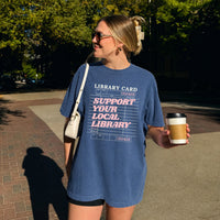 May include a Support Your Local Library Comfort Colors T-Shirt featuring a classic library-inspired statement design.