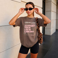May include a Support Your Local Library Comfort Colors T-Shirt featuring a classic library-inspired statement design.