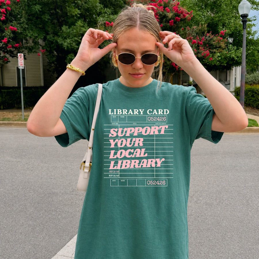 May include a Support Your Local Library Comfort Colors T-Shirt featuring a classic library-inspired statement design.