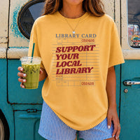May include a Support Your Local Library Comfort Colors T-Shirt featuring a classic library-inspired statement design.