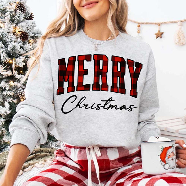 May include a close view of the words “Merry Christmas” printed on fabric, with the top word in a red and black buffalo plaid pattern and the script below in clean black lettering.