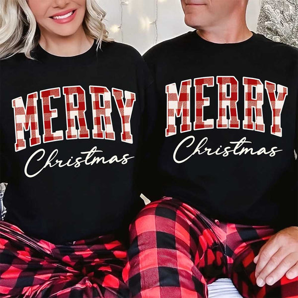 May include a close view of the words “Merry Christmas” printed on fabric, with the top word in a red and black buffalo plaid pattern and the script below in clean black lettering.