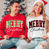 May include a close view of the words “Merry Christmas” printed on fabric, with the top word in a red and black buffalo plaid pattern and the script below in clean black lettering.