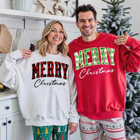 May include a close view of the words “Merry Christmas” printed on fabric, with the top word in a red and black buffalo plaid pattern and the script below in clean black lettering.