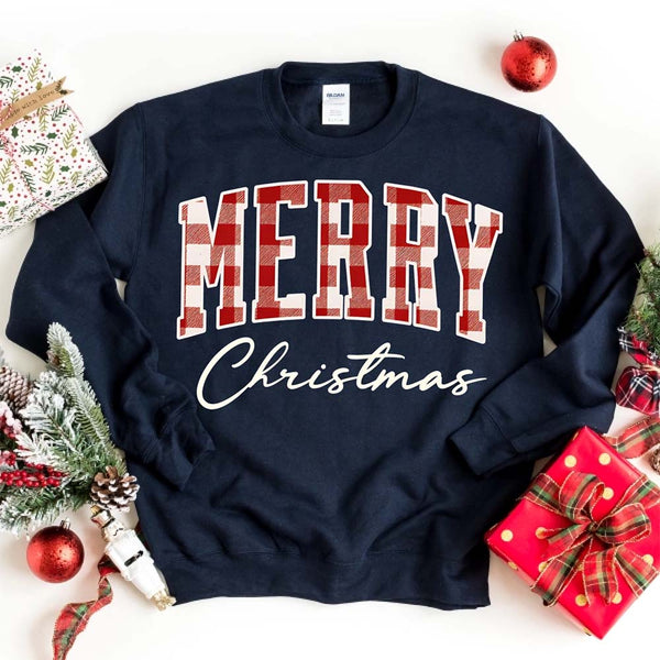 May include a close view of the words “Merry Christmas” printed on fabric, with the top word in a red and black buffalo plaid pattern and the script below in clean black lettering.