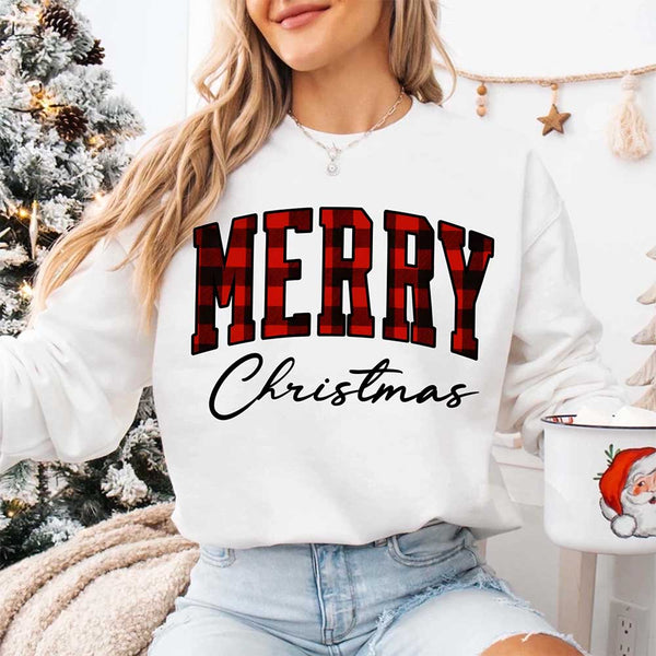 May include a close view of the words “Merry Christmas” printed on fabric, with the top word in a red and black buffalo plaid pattern and the script below in clean black lettering.