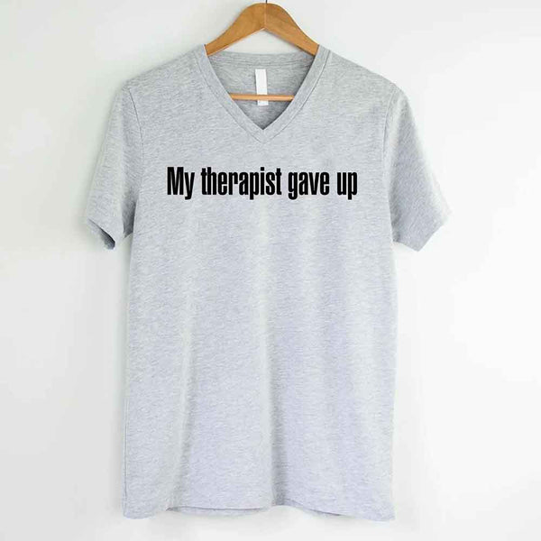 May include a V-neck T-shirt with the humorous phrase “My Therapist Gave Up” displayed on the front.