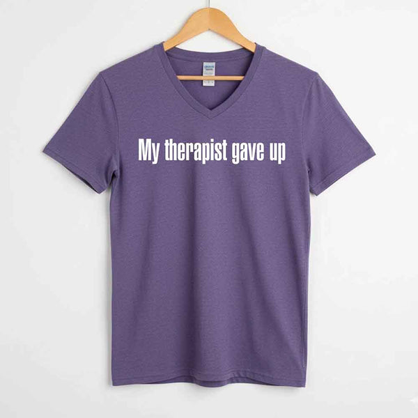 May include a V-neck T-shirt with the humorous phrase “My Therapist Gave Up” displayed on the front.