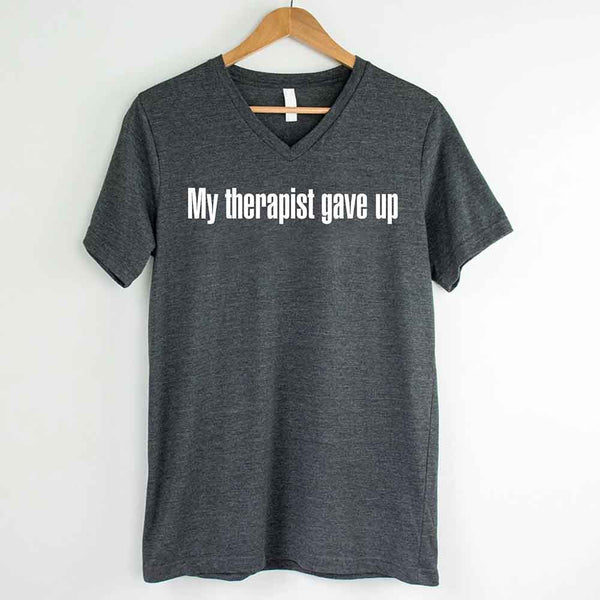 May include a V-neck T-shirt with the humorous phrase “My Therapist Gave Up” displayed on the front.