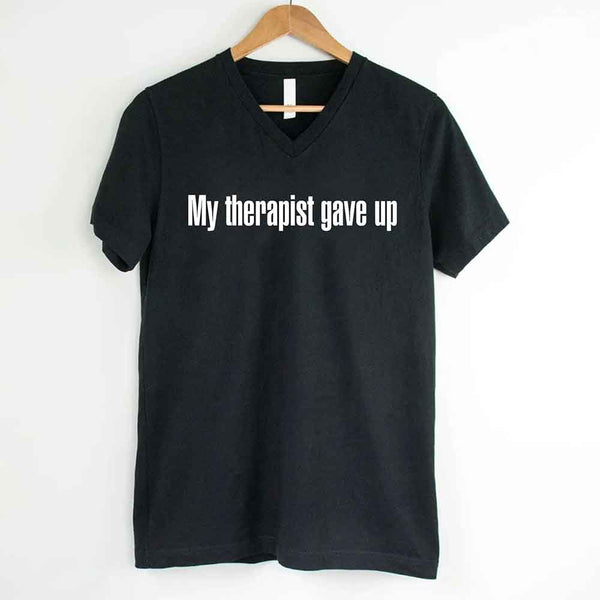 May include a V-neck T-shirt with the humorous phrase “My Therapist Gave Up” displayed on the front.