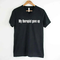 May include a V-neck T-shirt with the humorous phrase “My Therapist Gave Up” displayed on the front.