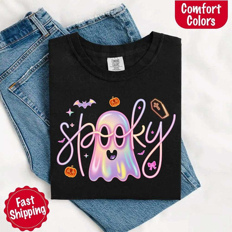 May include holographic ghost with happy face, pastel neon spooky text, pumpkins, bats, coffin, bow, and stars – trendy Halloween graphic tee design.