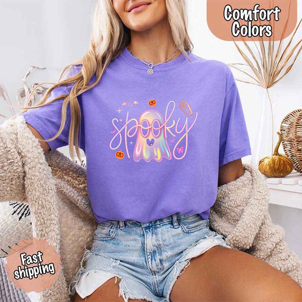 May include holographic ghost with happy face, pastel neon spooky text, pumpkins, bats, coffin, bow, and stars – trendy Halloween graphic tee design.