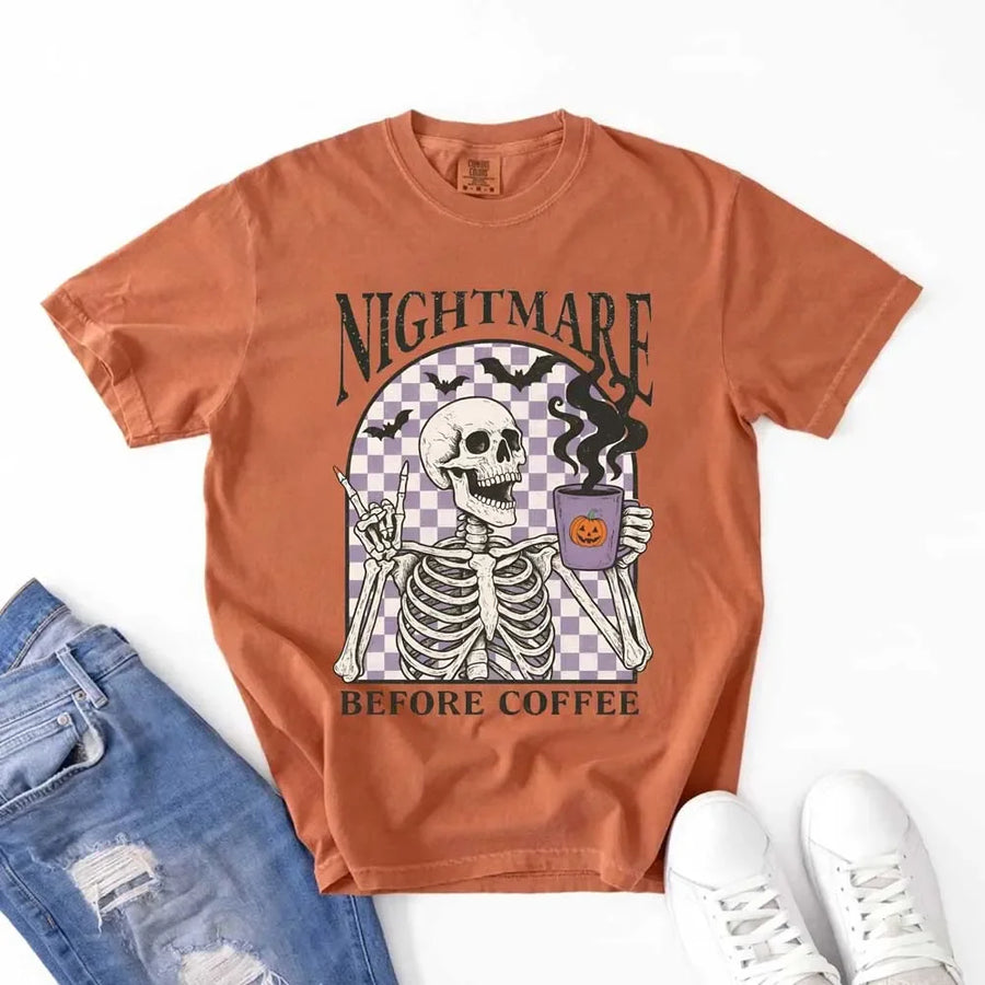 Nightmare Before Coffee skeleton graphic tee featuring skeleton holding a pumpkin coffee mug with steam, bats, and checkered background – funny Halloween coffee shirt.