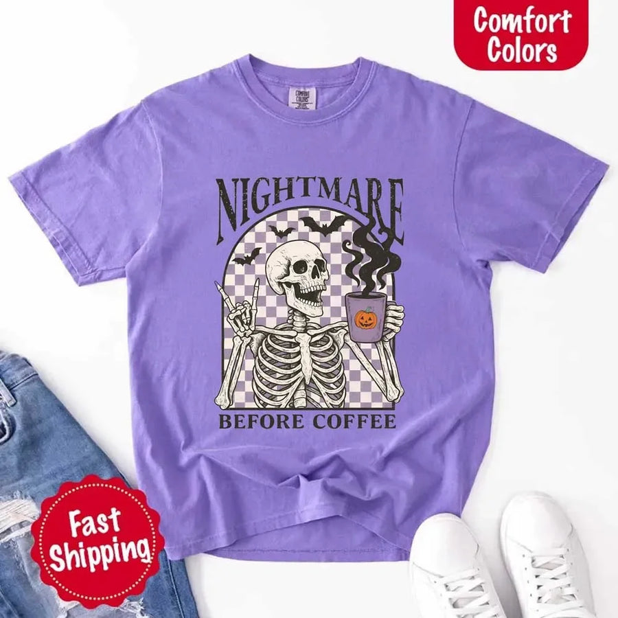 Nightmare Before Coffee skeleton graphic tee featuring skeleton holding a pumpkin coffee mug with steam, bats, and checkered background – funny Halloween coffee shirt.