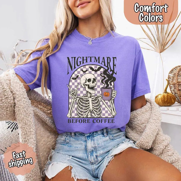 Nightmare Before Coffee skeleton graphic tee featuring skeleton holding a pumpkin coffee mug with steam, bats, and checkered background – funny Halloween coffee shirt.