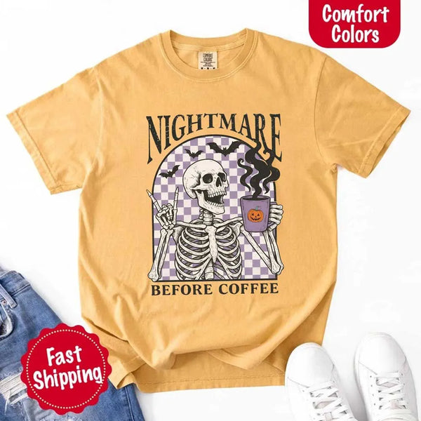 Nightmare Before Coffee skeleton graphic tee featuring skeleton holding a pumpkin coffee mug with steam, bats, and checkered background – funny Halloween coffee shirt.