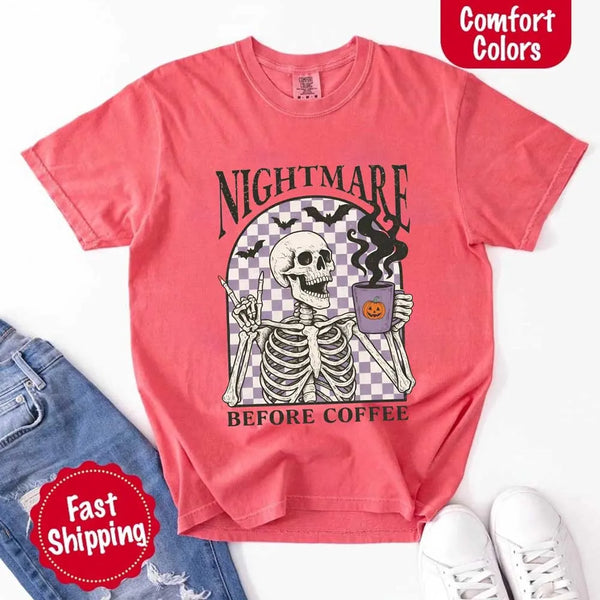 Nightmare Before Coffee skeleton graphic tee featuring skeleton holding a pumpkin coffee mug with steam, bats, and checkered background – funny Halloween coffee shirt.