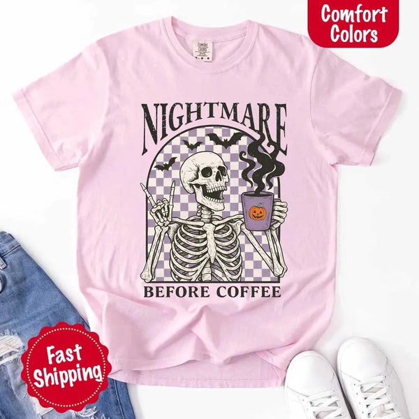 Nightmare Before Coffee skeleton graphic tee featuring skeleton holding a pumpkin coffee mug with steam, bats, and checkered background – funny Halloween coffee shirt.