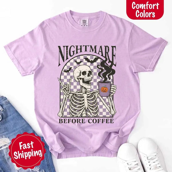 Nightmare Before Coffee skeleton graphic tee featuring skeleton holding a pumpkin coffee mug with steam, bats, and checkered background – funny Halloween coffee shirt.