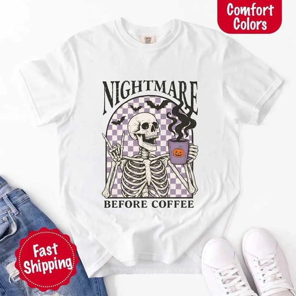 Nightmare Before Coffee skeleton graphic tee featuring skeleton holding a pumpkin coffee mug with steam, bats, and checkered background – funny Halloween coffee shirt.