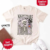 Nightmare Before Coffee skeleton graphic tee featuring skeleton holding a pumpkin coffee mug with steam, bats, and checkered background – funny Halloween coffee shirt.