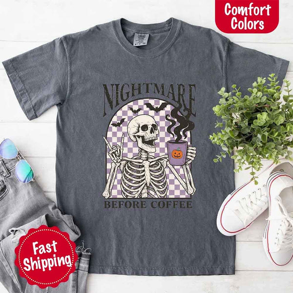 Nightmare Before Coffee skeleton graphic tee featuring skeleton holding a pumpkin coffee mug with steam, bats, and checkered background – funny Halloween coffee shirt.