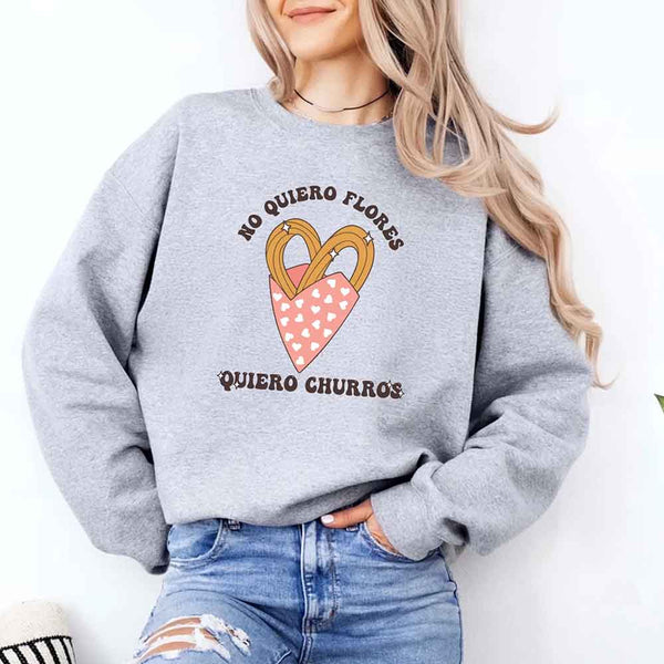 May include a crewneck sweatshirt with a No Quiero Flores Valentine design and a cute churros illustration.