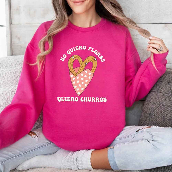May include a crewneck sweatshirt with a No Quiero Flores Valentine design and a cute churros illustration.