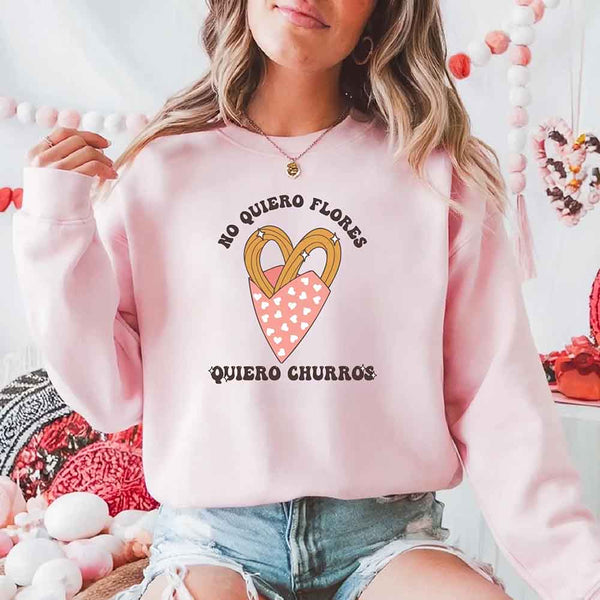 May include a crewneck sweatshirt with a No Quiero Flores Valentine design and a cute churros illustration.