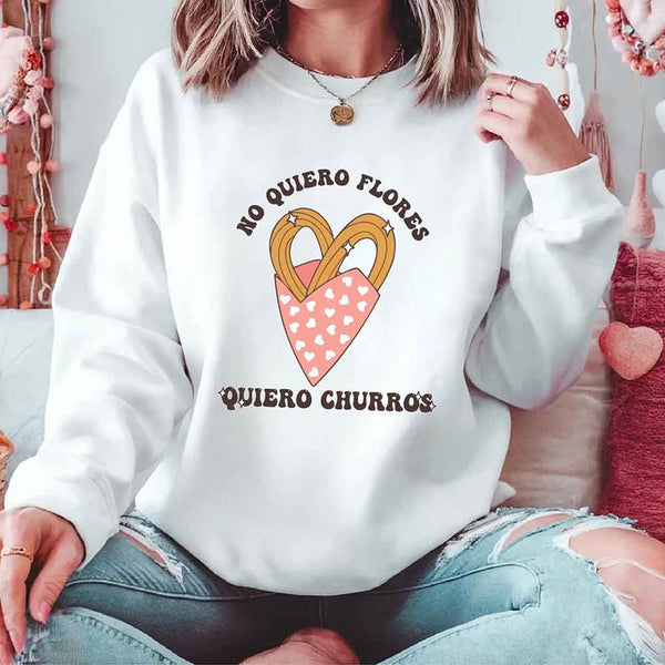 May include a crewneck sweatshirt with a No Quiero Flores Valentine design and a cute churros illustration.