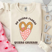 May include a crewneck sweatshirt with a No Quiero Flores Valentine design and a cute churros illustration.