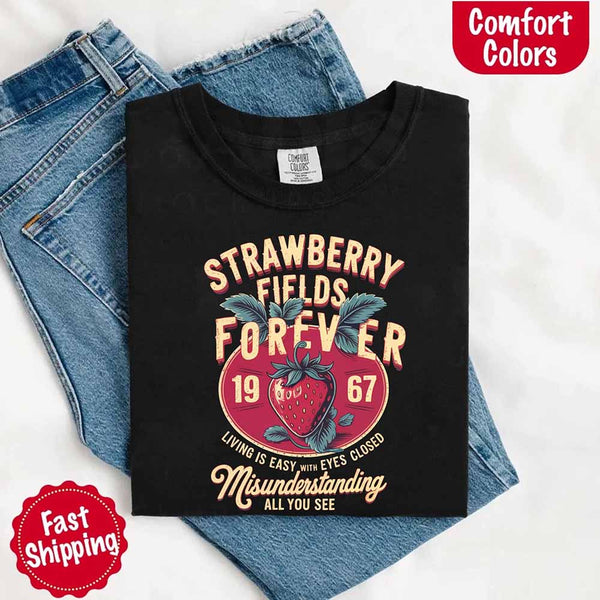 May include vintage-style artwork with a large strawberry and bold text that reads “Strawberry Fields Forever 1967,” along with the phrases “Living is easy with eyes closed” and “Misunderstanding all you see,” inspired by nostalgic and psychedelic themes.