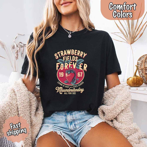 May include vintage-style artwork with a large strawberry and bold text that reads “Strawberry Fields Forever 1967,” along with the phrases “Living is easy with eyes closed” and “Misunderstanding all you see,” inspired by nostalgic and psychedelic themes.