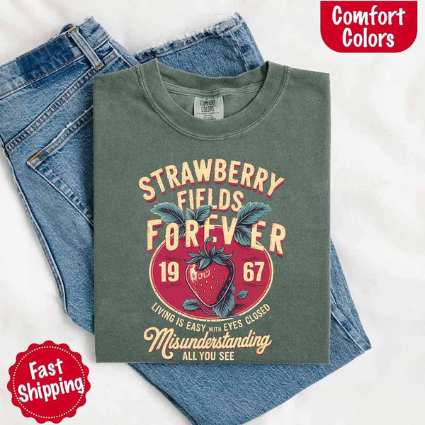May include vintage-style artwork with a large strawberry and bold text that reads “Strawberry Fields Forever 1967,” along with the phrases “Living is easy with eyes closed” and “Misunderstanding all you see,” inspired by nostalgic and psychedelic themes.