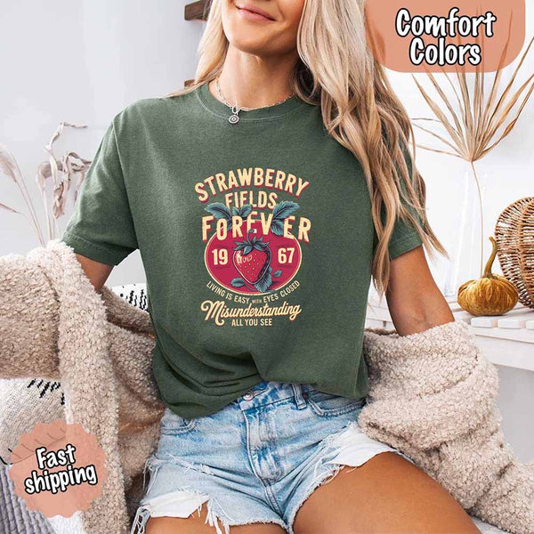 May include vintage-style artwork with a large strawberry and bold text that reads “Strawberry Fields Forever 1967,” along with the phrases “Living is easy with eyes closed” and “Misunderstanding all you see,” inspired by nostalgic and psychedelic themes.