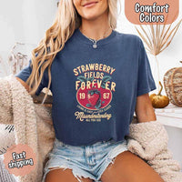 May include vintage-style artwork with a large strawberry and bold text that reads “Strawberry Fields Forever 1967,” along with the phrases “Living is easy with eyes closed” and “Misunderstanding all you see,” inspired by nostalgic and psychedelic themes.