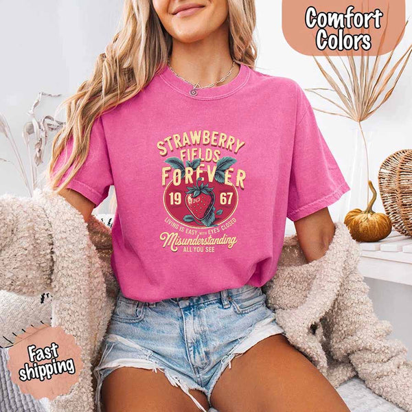 May include vintage-style artwork with a large strawberry and bold text that reads “Strawberry Fields Forever 1967,” along with the phrases “Living is easy with eyes closed” and “Misunderstanding all you see,” inspired by nostalgic and psychedelic themes.