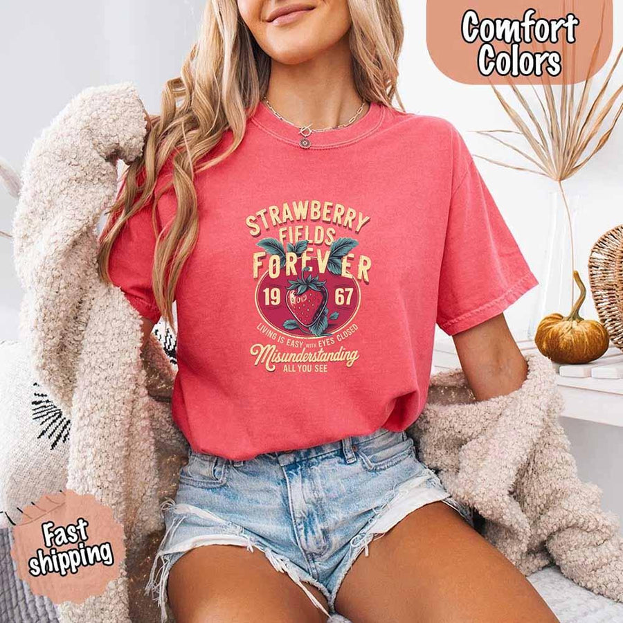 May include vintage-style artwork with a large strawberry and bold text that reads “Strawberry Fields Forever 1967,” along with the phrases “Living is easy with eyes closed” and “Misunderstanding all you see,” inspired by nostalgic and psychedelic themes.