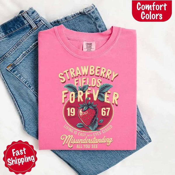 May include vintage-style artwork with a large strawberry and bold text that reads “Strawberry Fields Forever 1967,” along with the phrases “Living is easy with eyes closed” and “Misunderstanding all you see,” inspired by nostalgic and psychedelic themes.