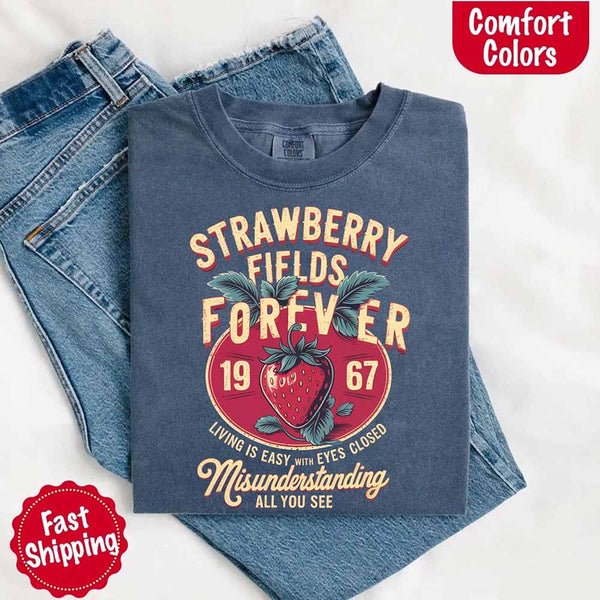 May include vintage-style artwork with a large strawberry and bold text that reads “Strawberry Fields Forever 1967,” along with the phrases “Living is easy with eyes closed” and “Misunderstanding all you see,” inspired by nostalgic and psychedelic themes.