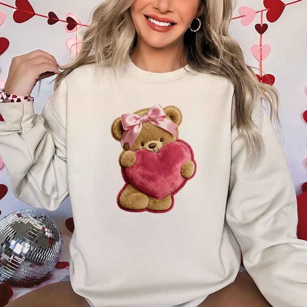 May include a crewneck sweatshirt with a plush teddy Valentine design featuring a furry-look 3D printed effect.