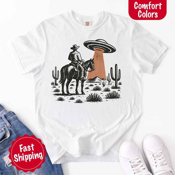 Retro cowboy and horse graphic with UFO beaming light in desert landscape with cacti – western alien mashup design