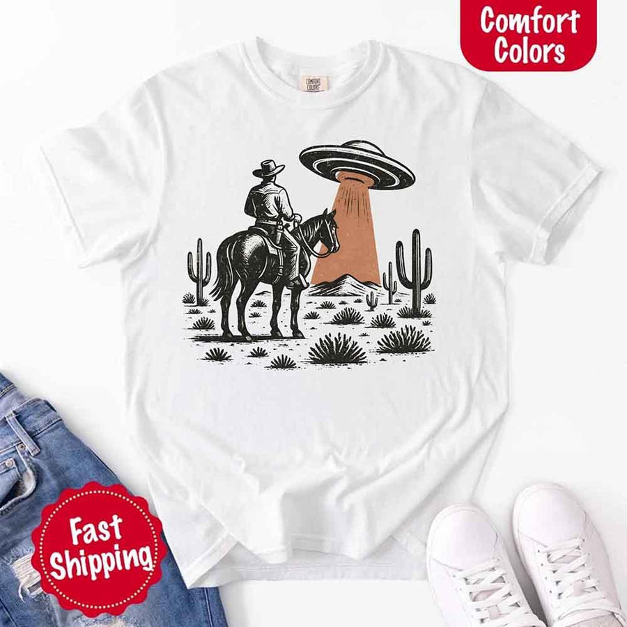 Retro cowboy and horse graphic with UFO beaming light in desert landscape with cacti – western alien mashup design